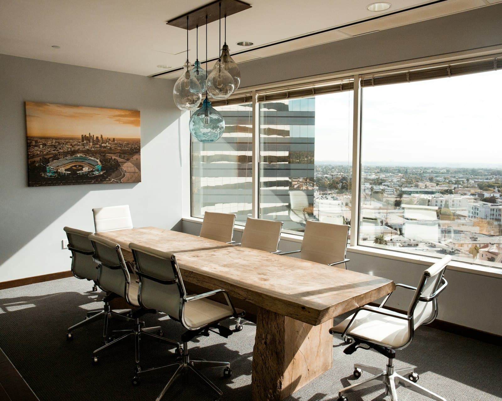 A meeting room with a long wooden table and city views