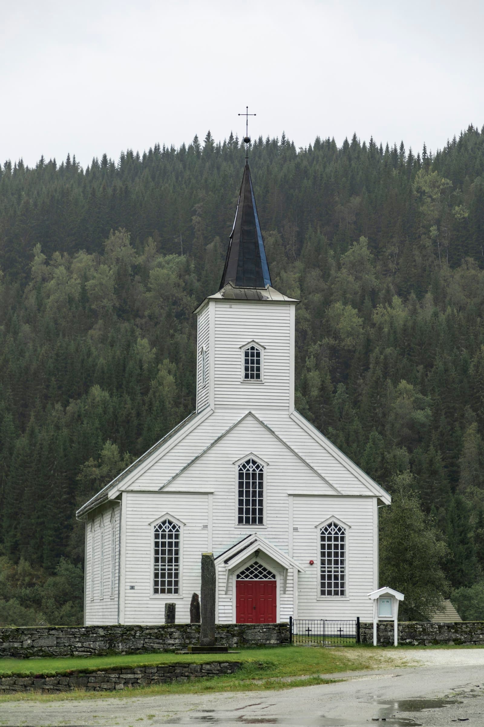 A white wooden church with a red door
